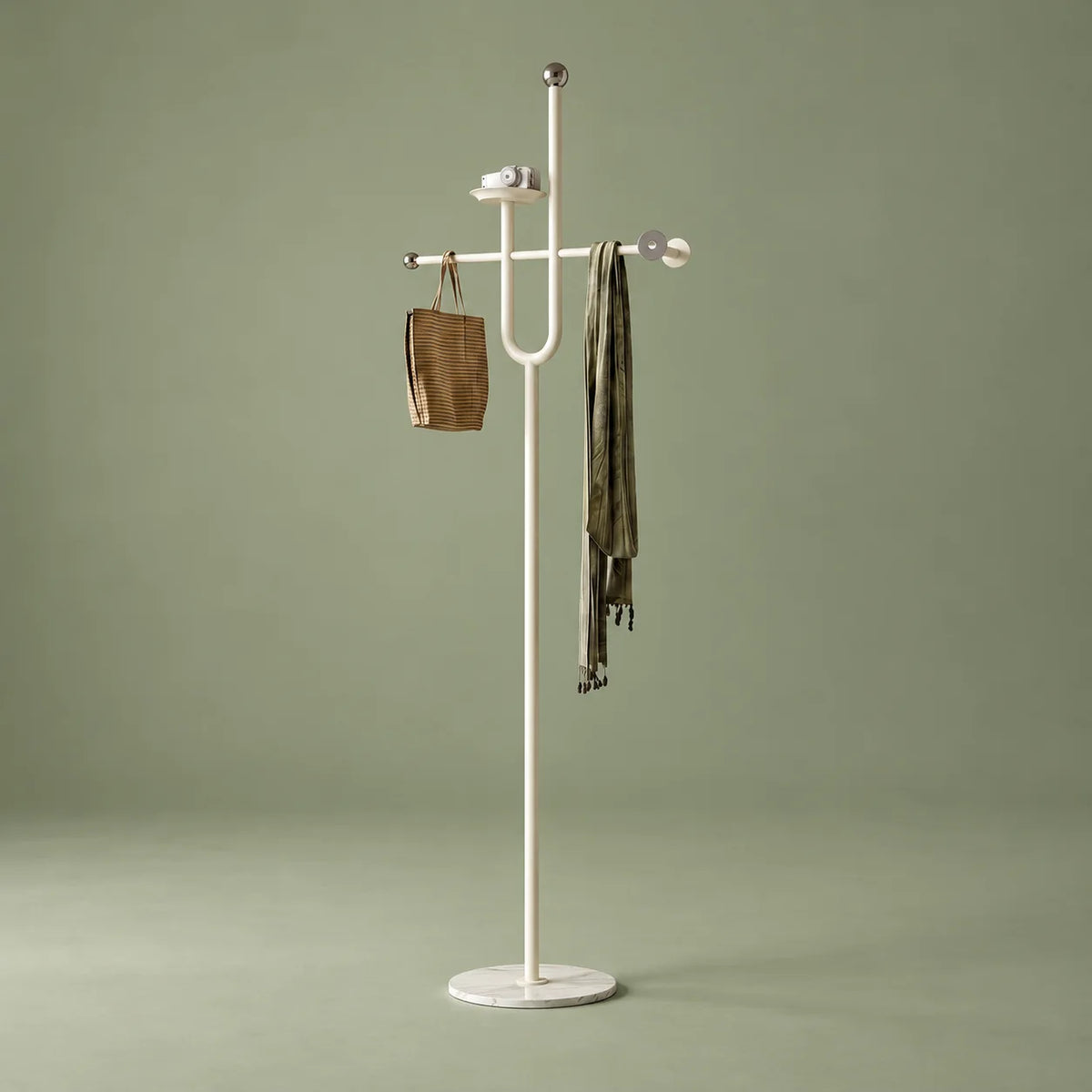 Porte-manteau blanc en aluminium à tablette, traverse, sac tissé et écharpe olive sur fond vert sauge