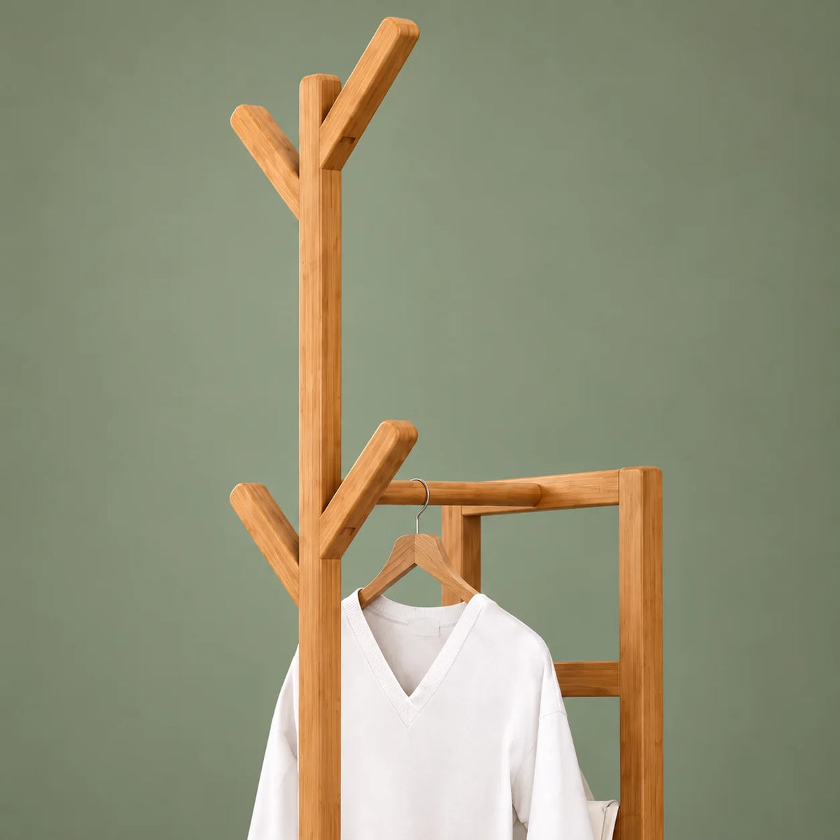 Gros plan des branches en bois clair et de la barre de suspension du porte-manteau