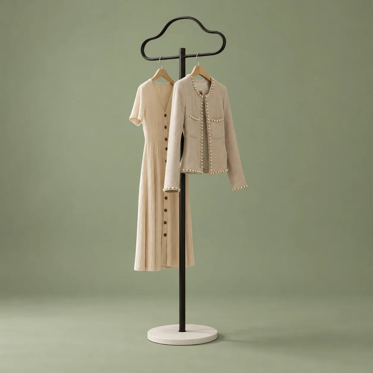 Porte-manteau Nuage noir portant deux vêtements sur fond vert sauge