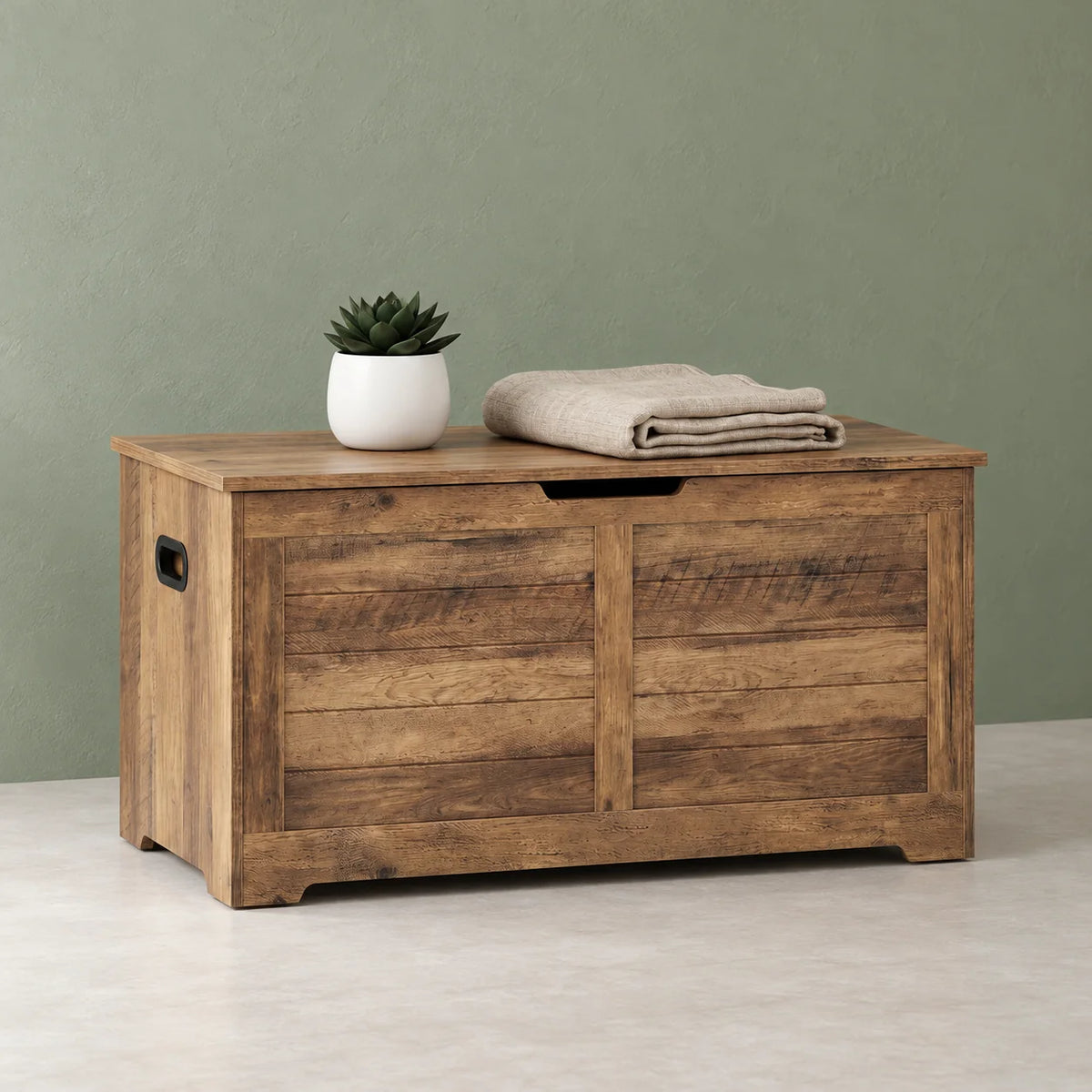 Vue de trois quarts gauche du coffre de rangement en bois rustique sur fond vert sauge