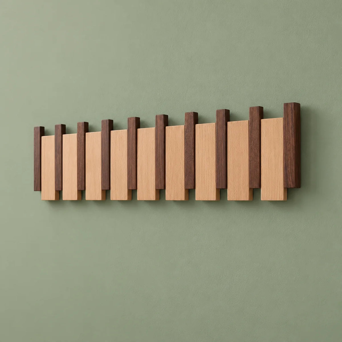 Vue oblique du grand porte-manteau mural en bois bicolore sur fond vert sauge