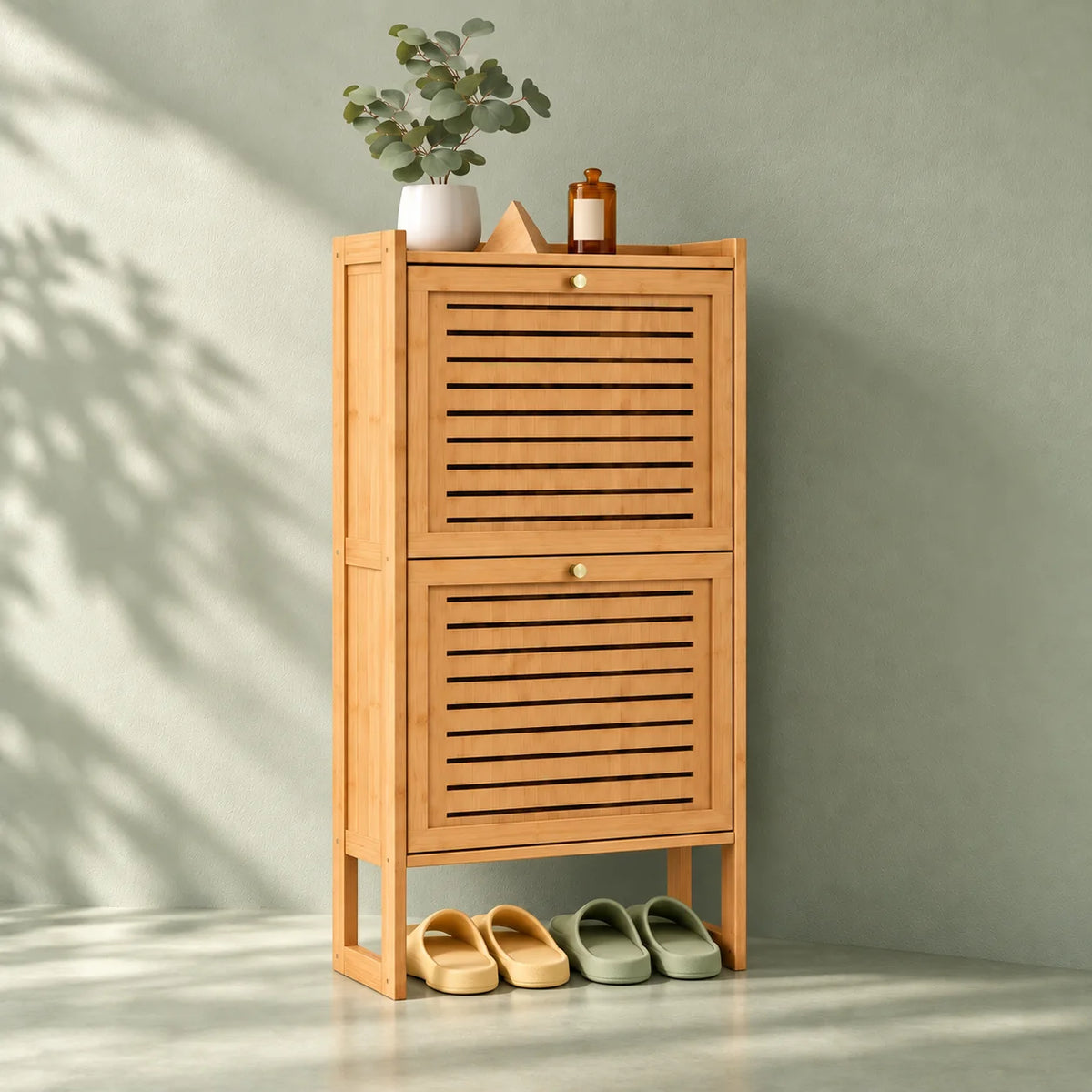 Vue de trois quarts gauche du meuble à chaussures compact en bambou sur fond vert sauge