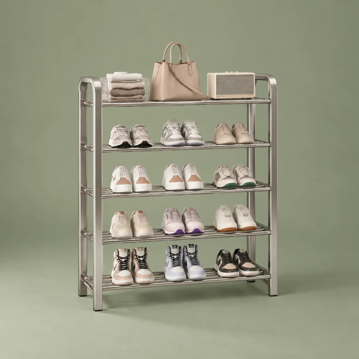 Vue de trois quarts gauche du meuble à chaussures en acier argenté sur fond vert sauge
