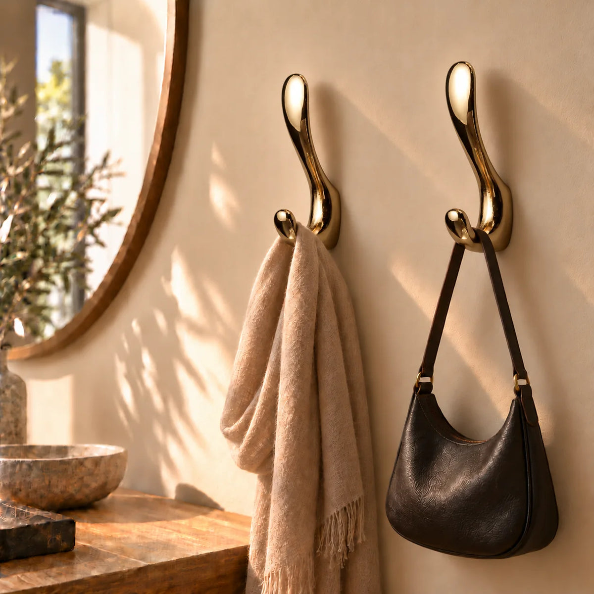 Deux exemplaires de la patère à crochet doré brillant avec écharpe et sac dans une entrée