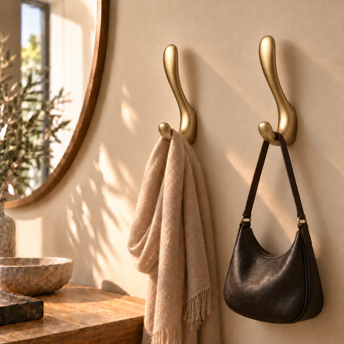 Deux exemplaires de la patère crochet dorée avec écharpe et sac dans une entrée