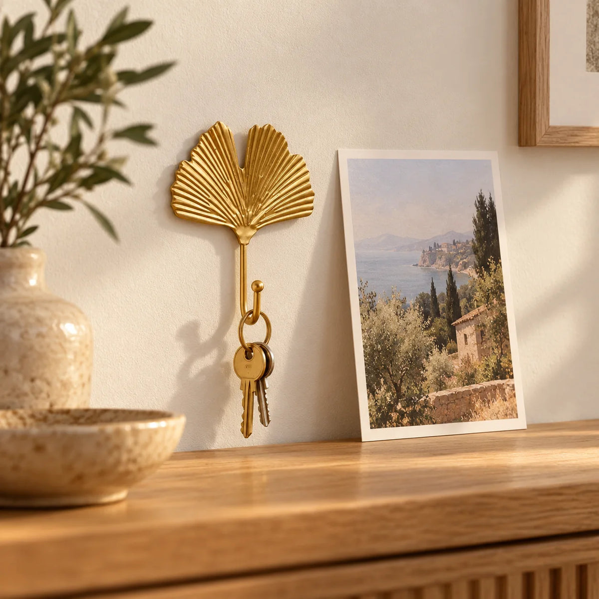 Petite patère Feuille dorée avec clés près d'une carte postale
