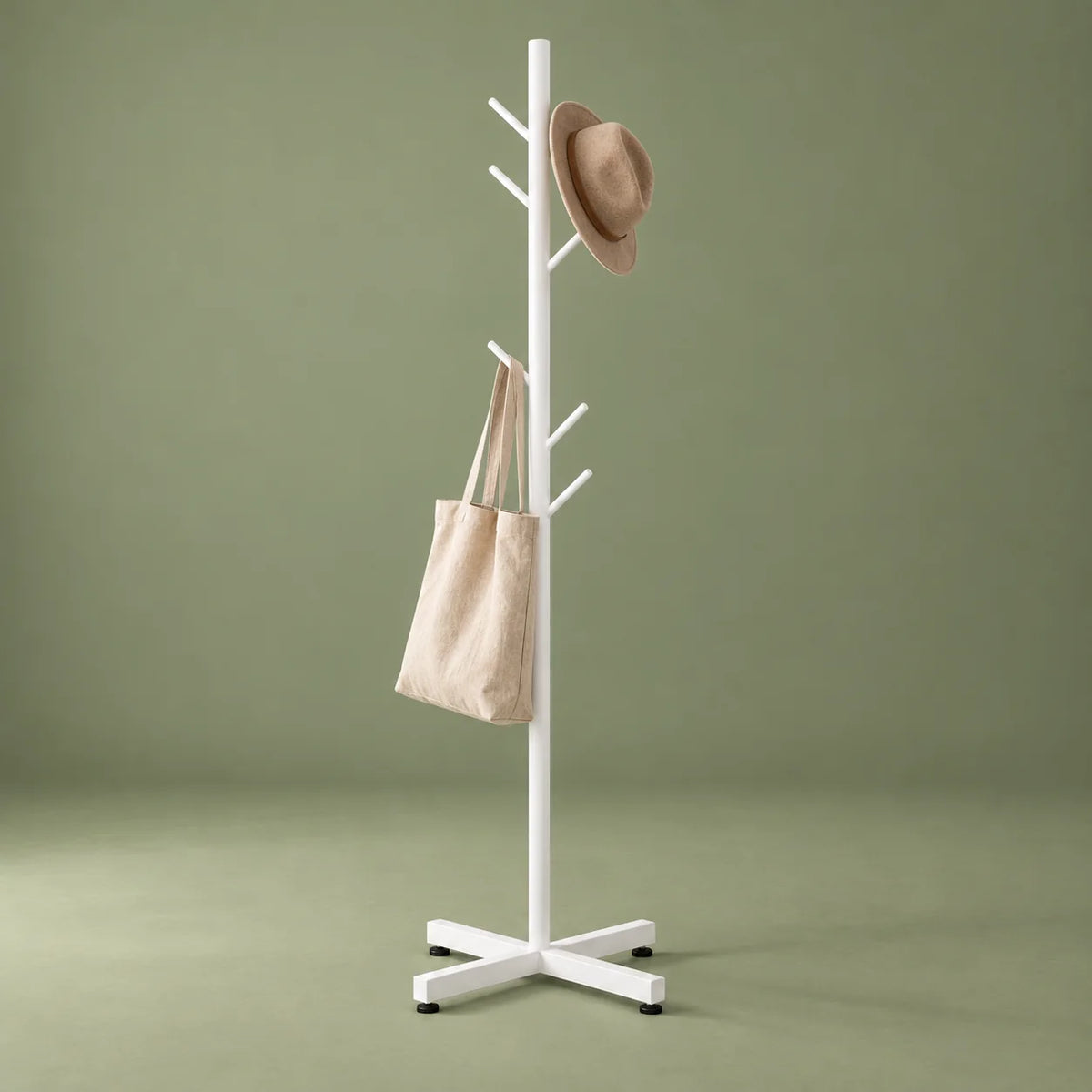 Porte-manteau arbre blanc avec chapeau et sac en toile sur fond vert sauge