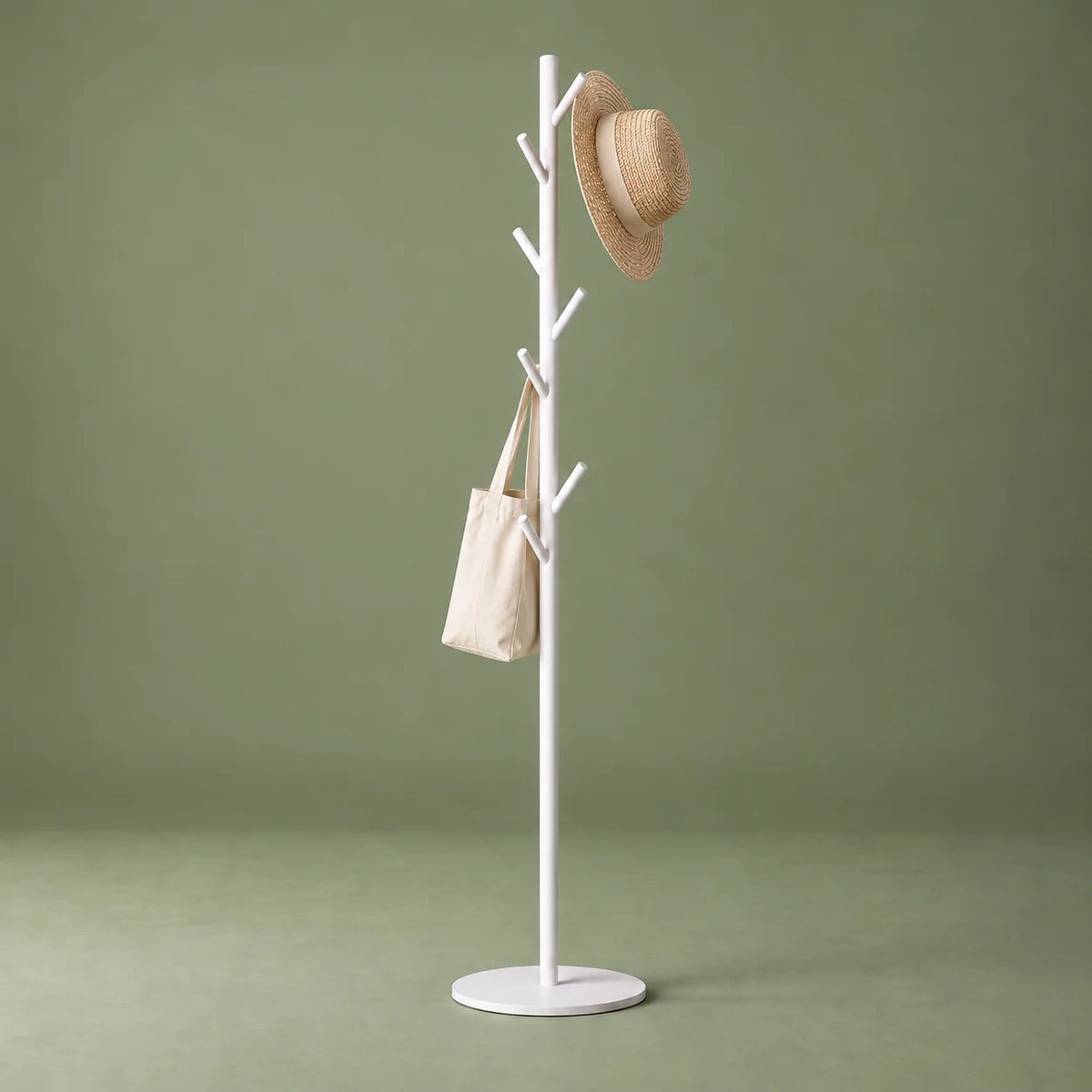 Porte-manteau arbre blanc avec chapeau et sac en toile sur fond vert sauge