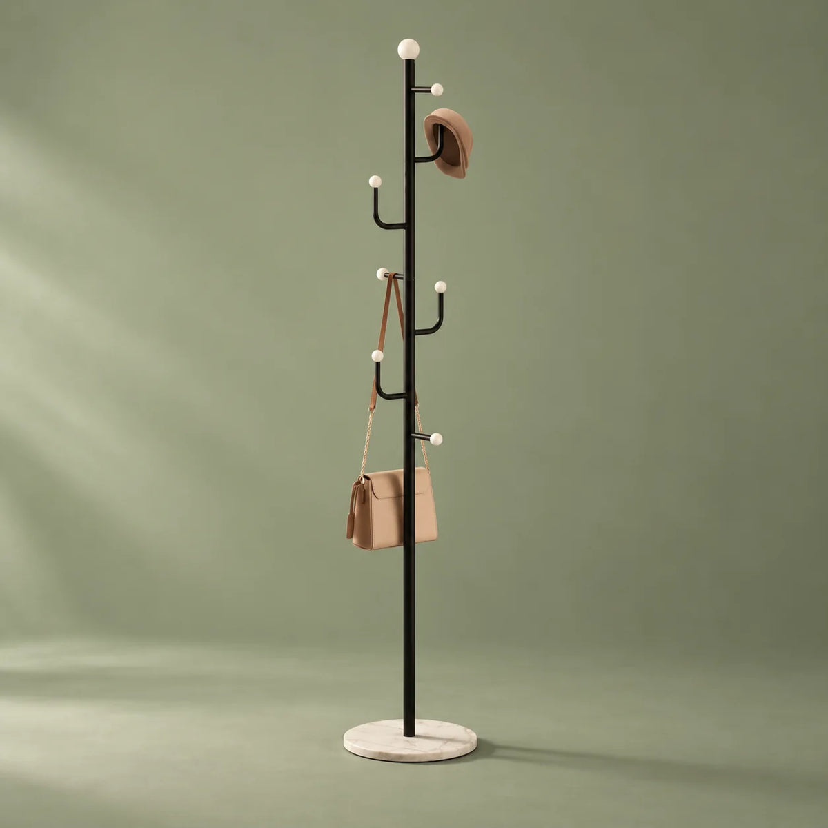 Vue entière du porte-manteau noir à embouts blancs et base ronde blanche sur fond vert sauge