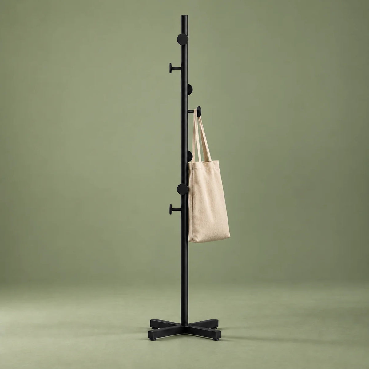 Porte-manteau champignon noir avec sac en toile sur fond vert sauge