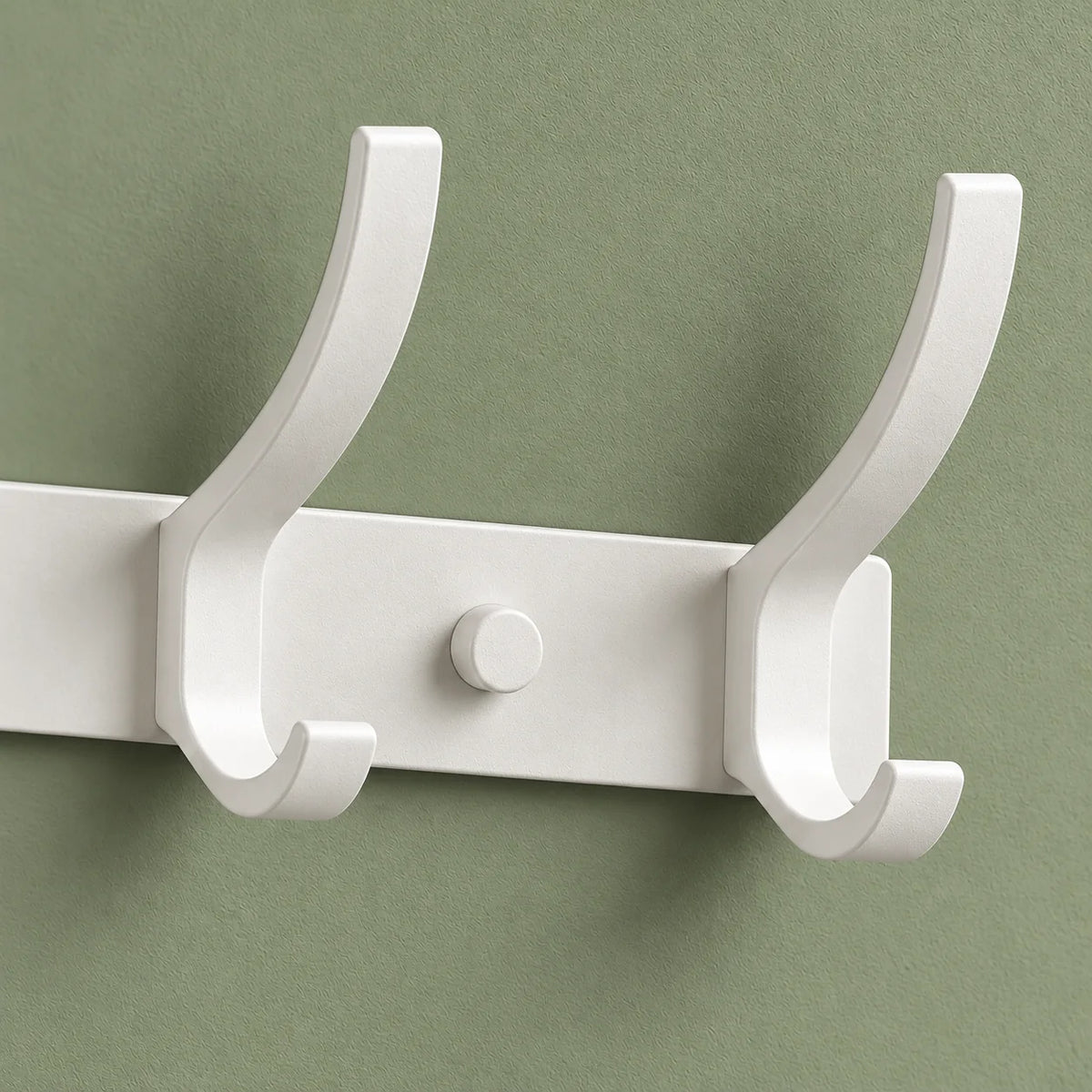 Détail des deux crochets blancs de droite et du capuchon de fixation sur fond vert sauge