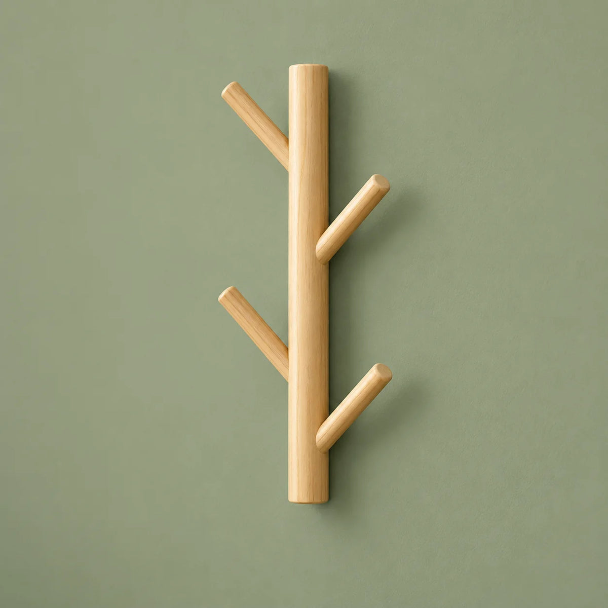 Porte-manteau mural en bois clair vu en angle sur fond vert sauge
