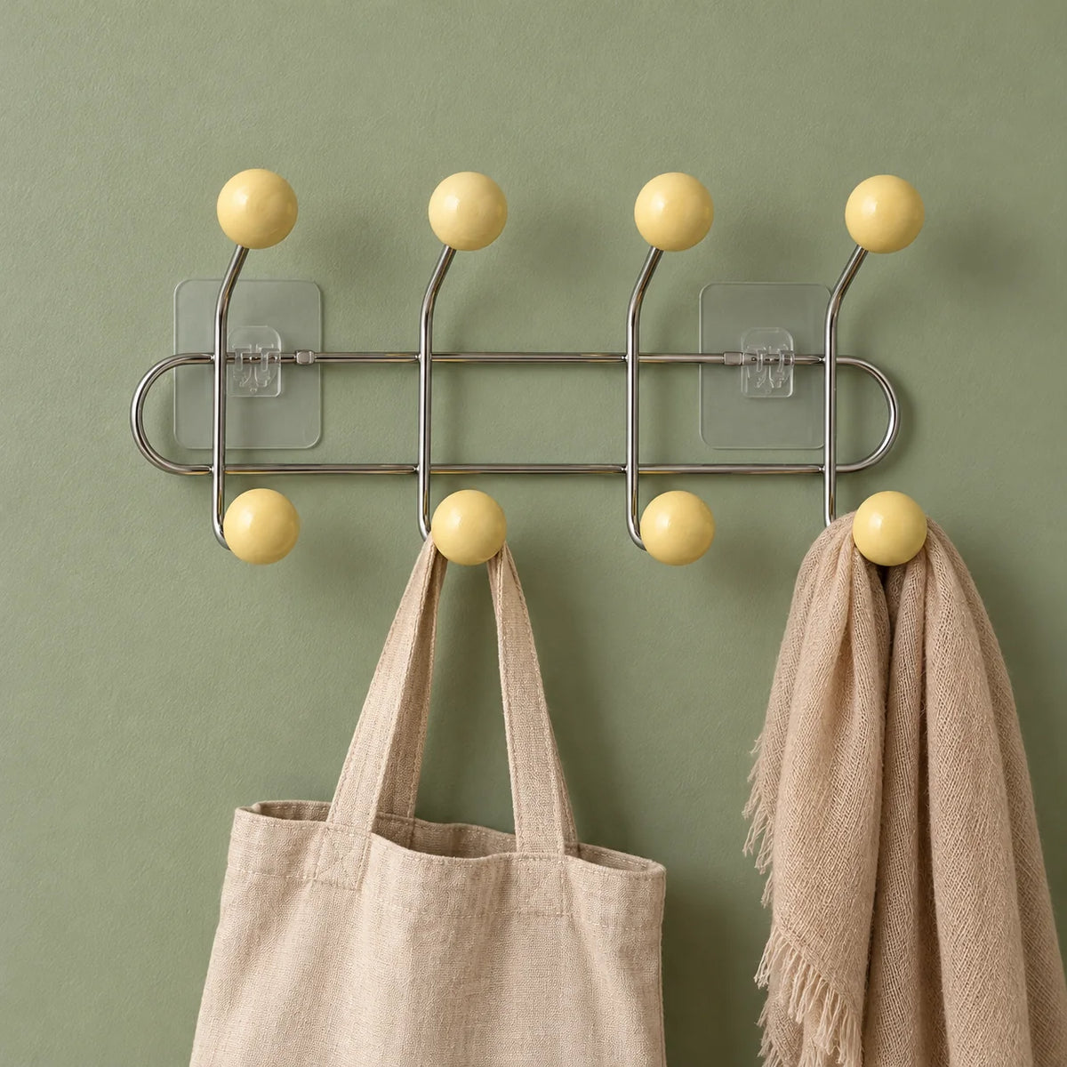Porte-manteau mural chromé avec sac en lin et écharpe sur fond vert sauge
