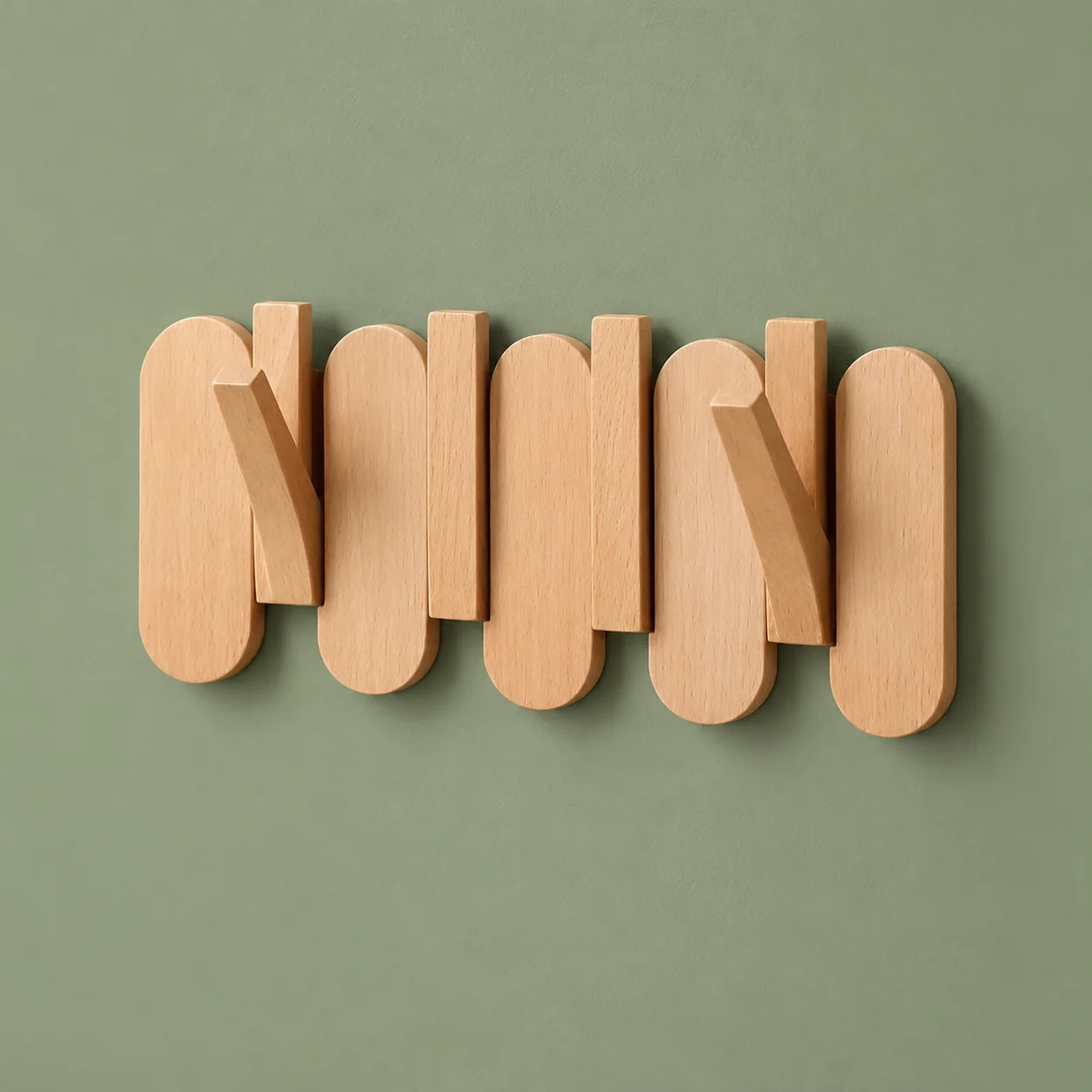 Petit porte-manteau mural en bois clair avec deux crochets ouverts sur fond vert sauge