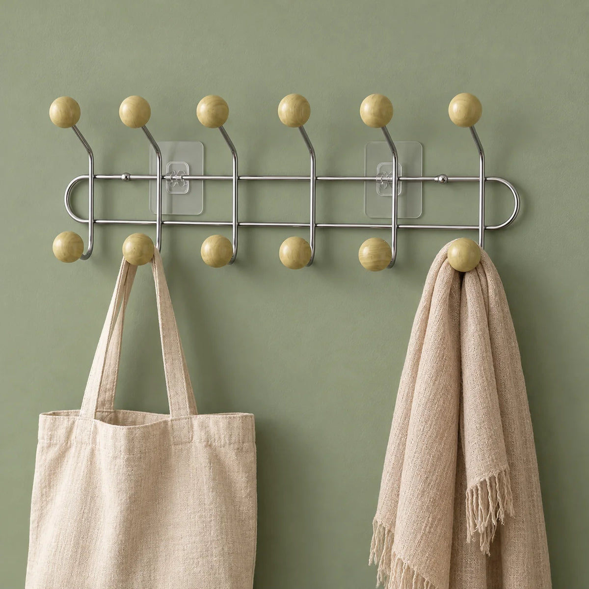 Porte-manteau mural chromé avec sac en lin et écharpe sur fond vert sauge