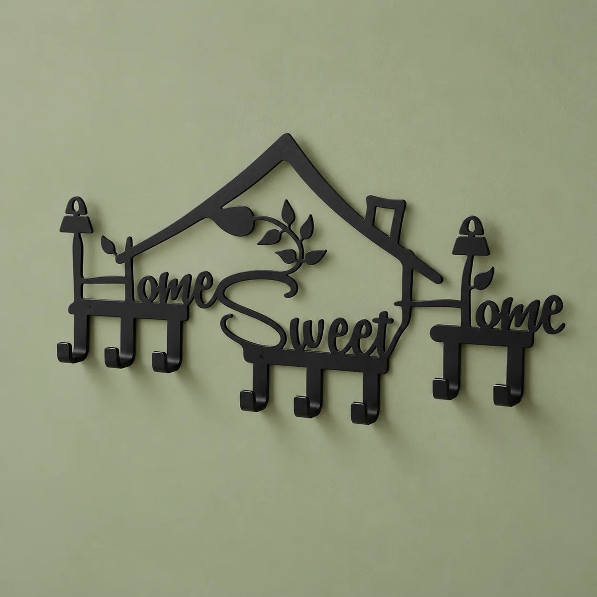 Vue de biais du porte-manteau Home Sweet Home noir sur fond vert sauge