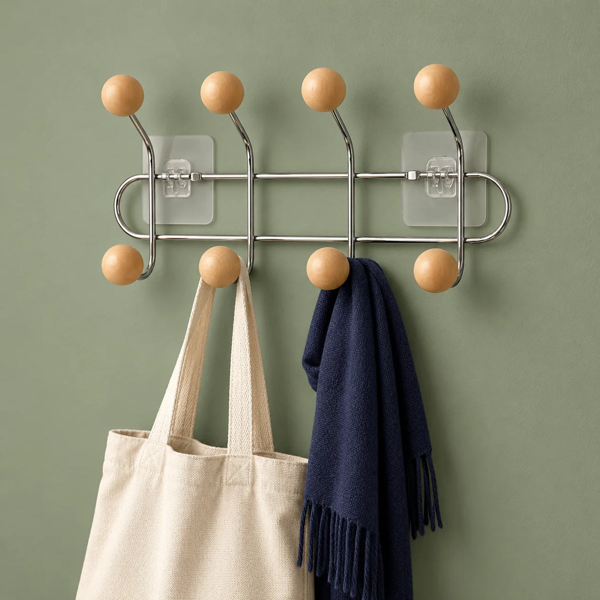 Porte-manteau chromé à boules bois avec sac et écharpe sur fond vert sauge