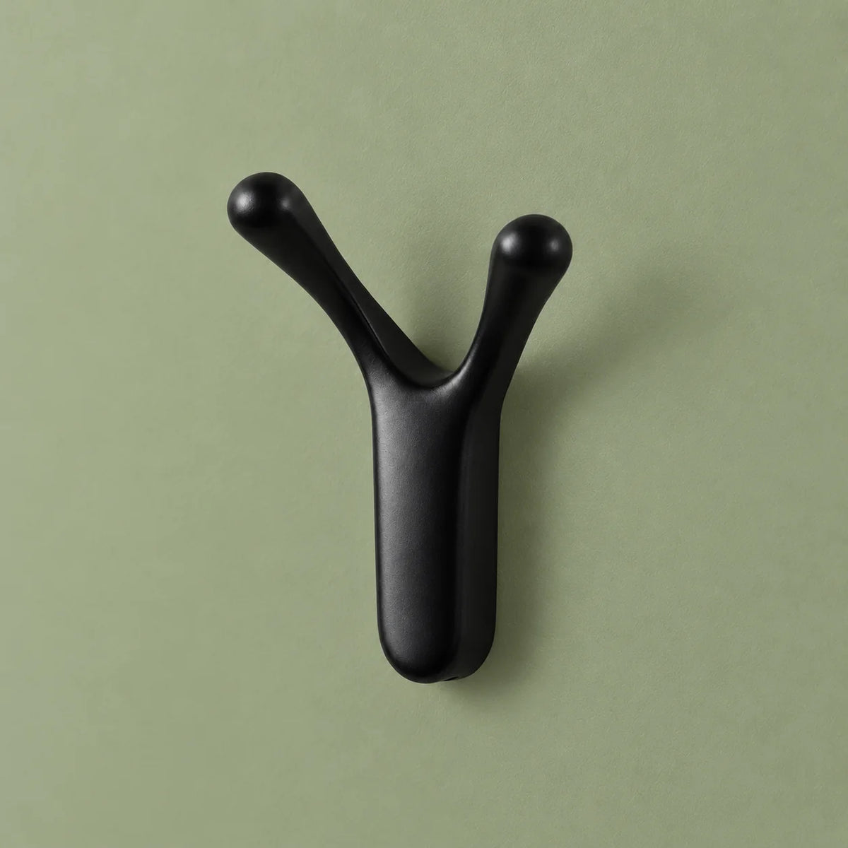 Patère Antenne noire sous un autre angle sur fond vert sauge