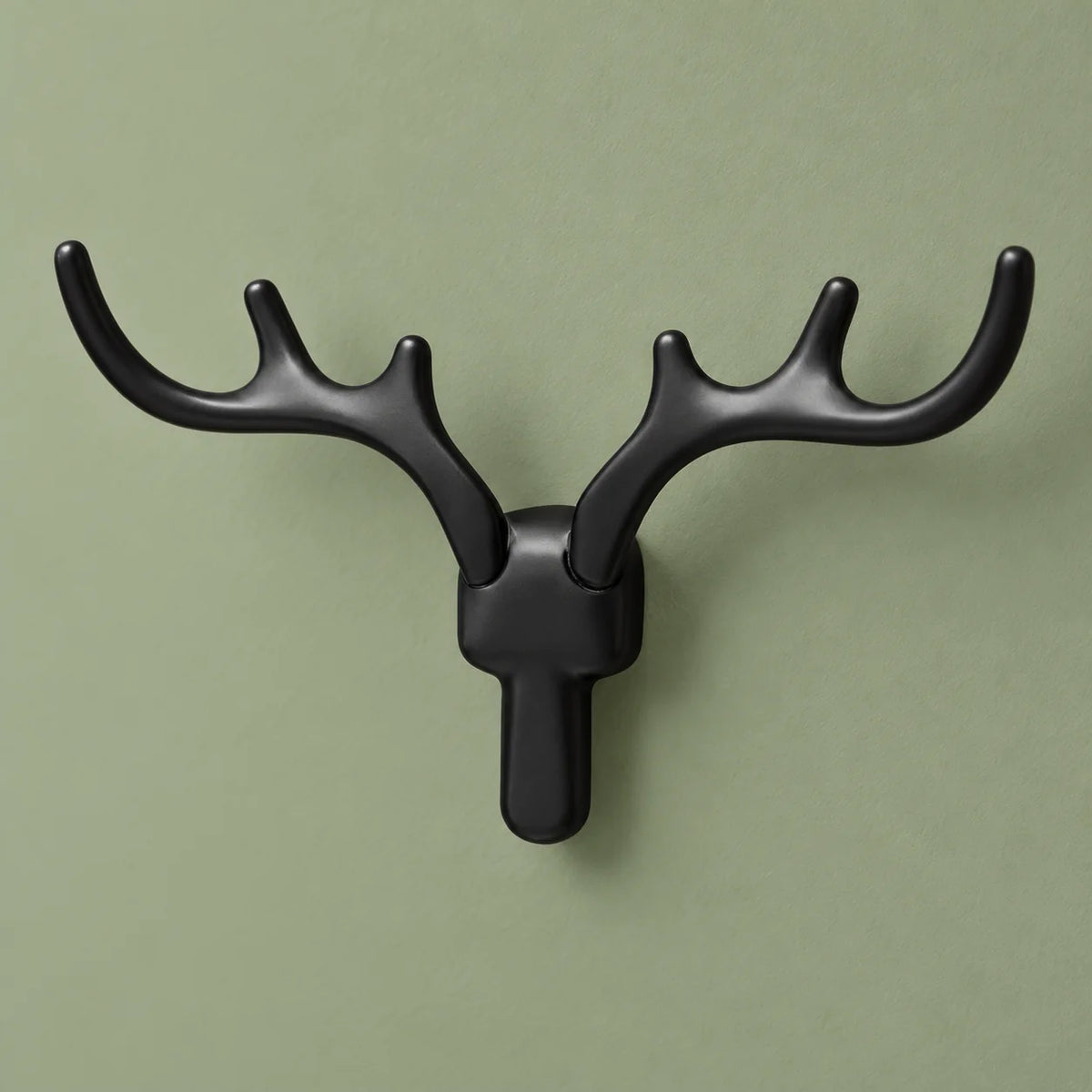 Patère cerf noire vue sous un autre angle sur fond vert sauge