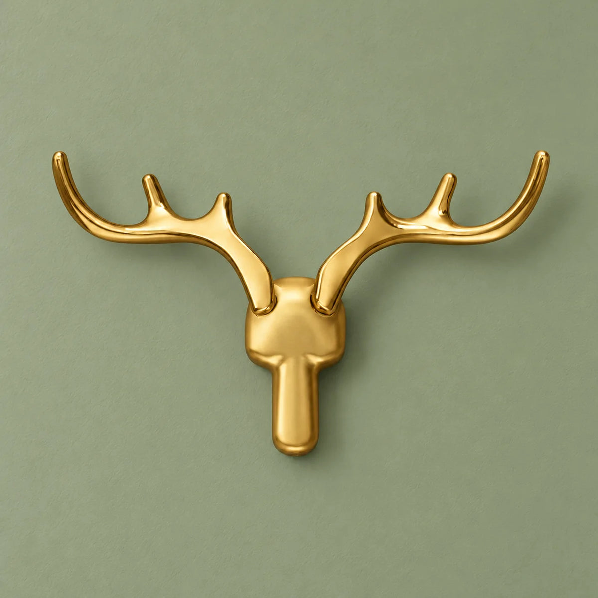 Patère cerf dorée vue de face sur fond vert sauge