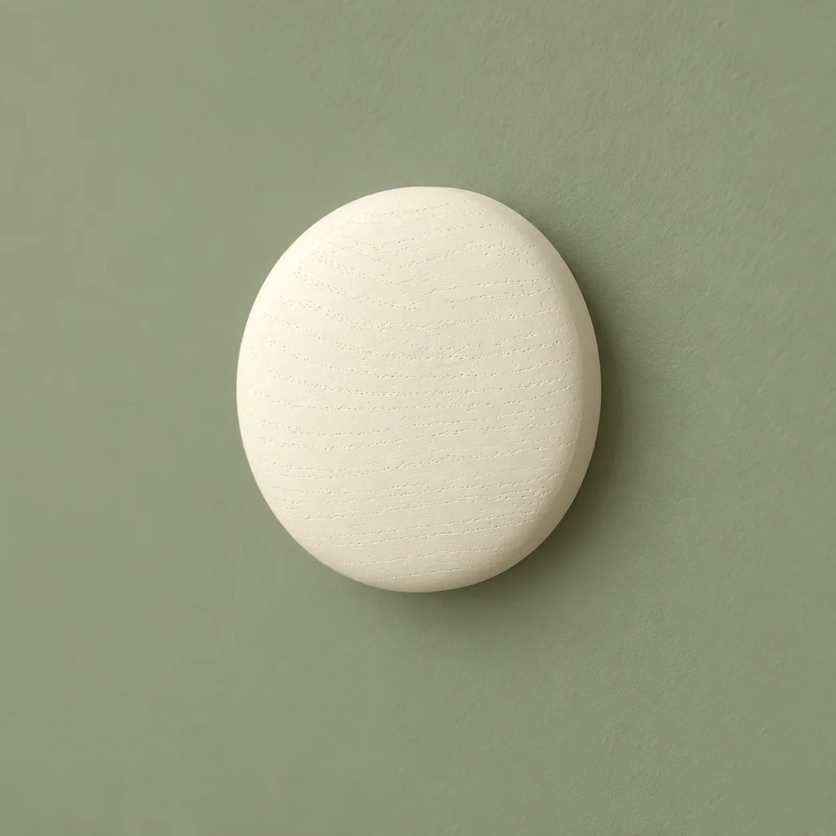 Patère ronde blanche vue de trois quarts sur fond vert sauge