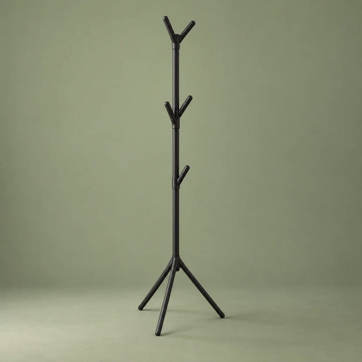 Porte-manteau sur pied noir vu de trois quarts sur fond vert sauge