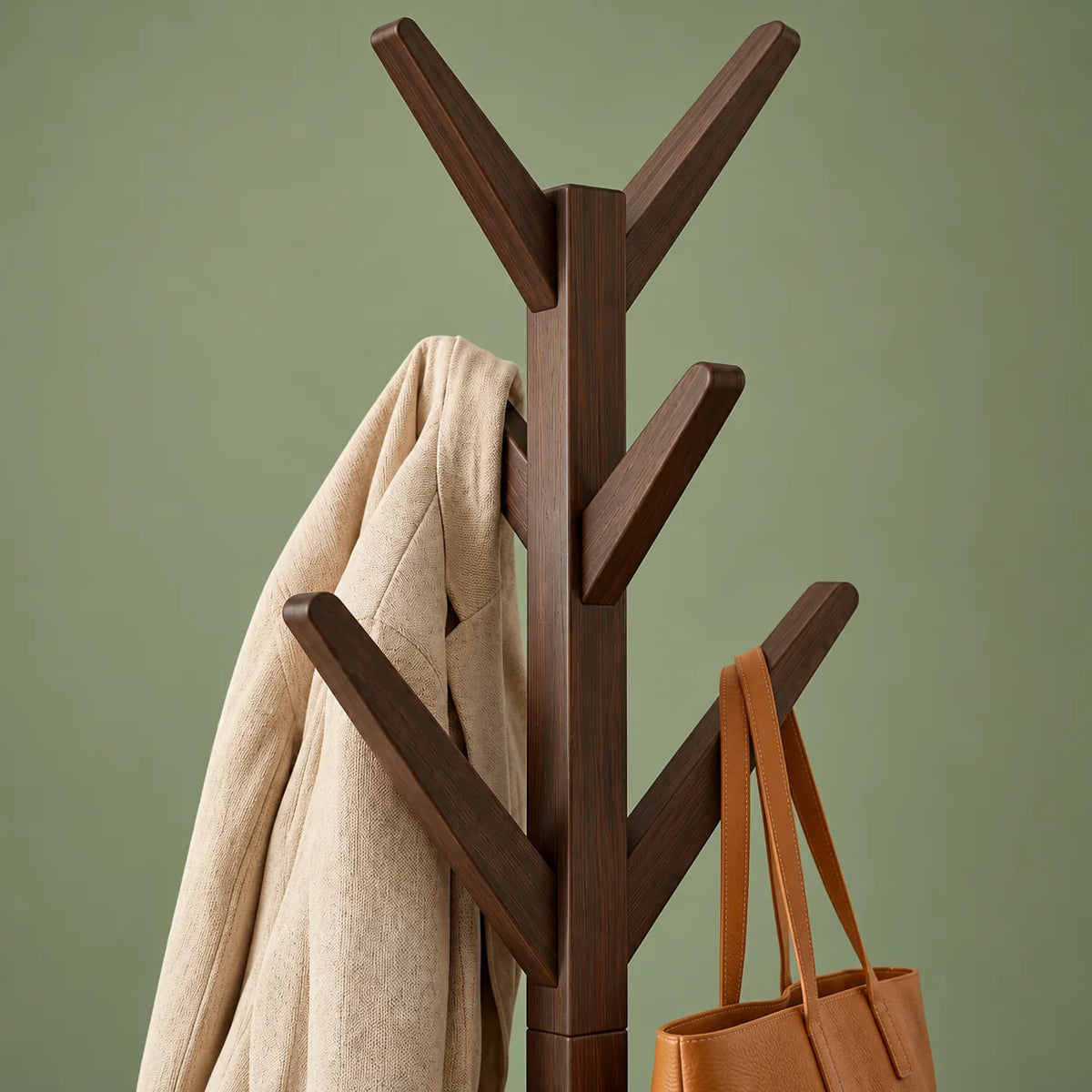 Détail de la fourche supérieure et des crochets en bois foncé sur fond vert