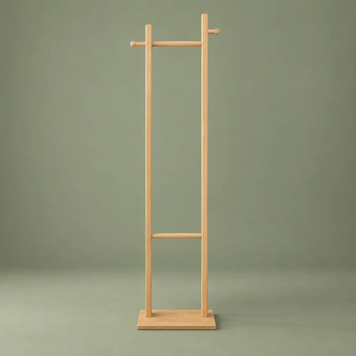 Vue de face du porte-manteau sur pied en bois clair à deux montants sur fond vert sauge