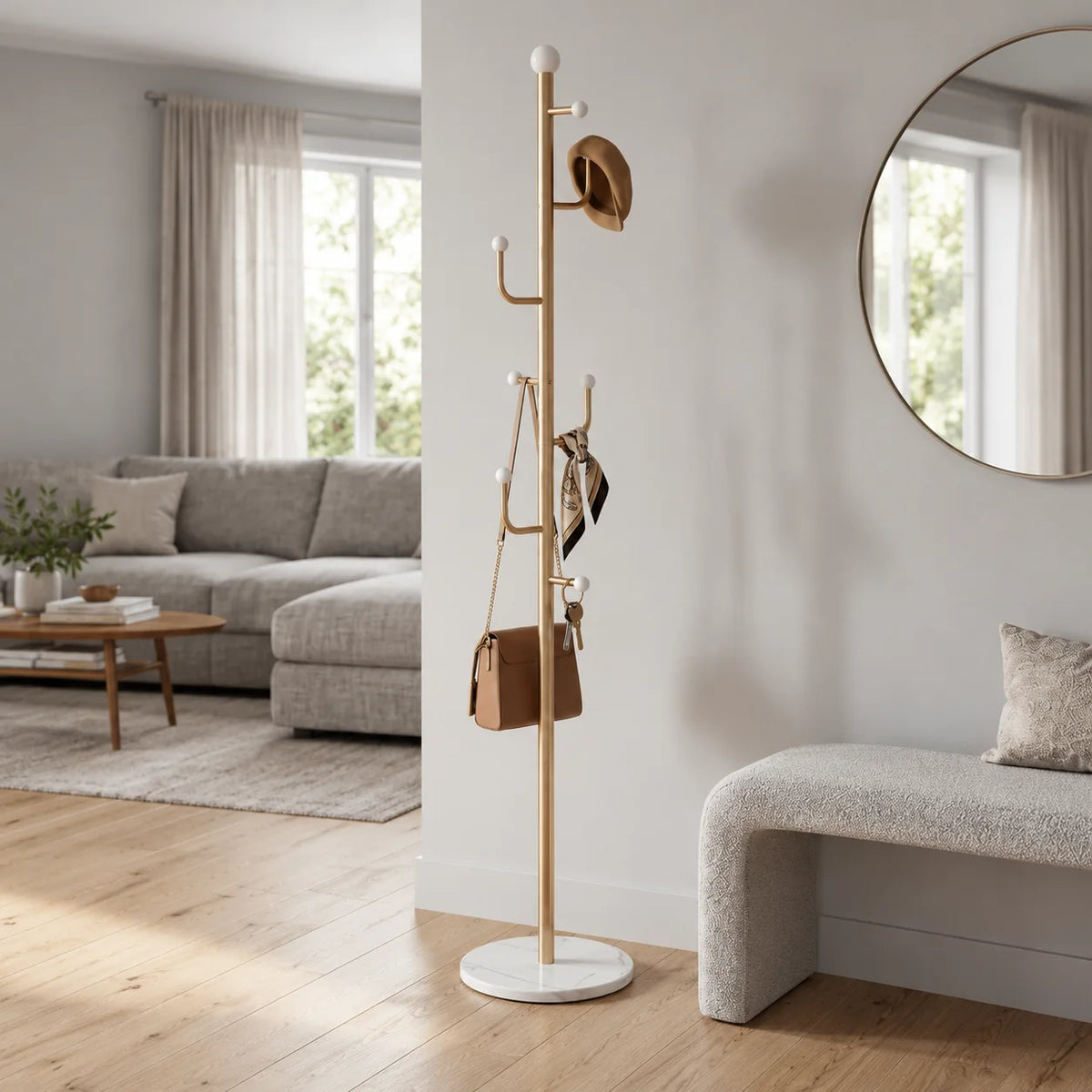 Porte-manteau doré vu d’un autre angle près d’une banquette et d’un miroir rond