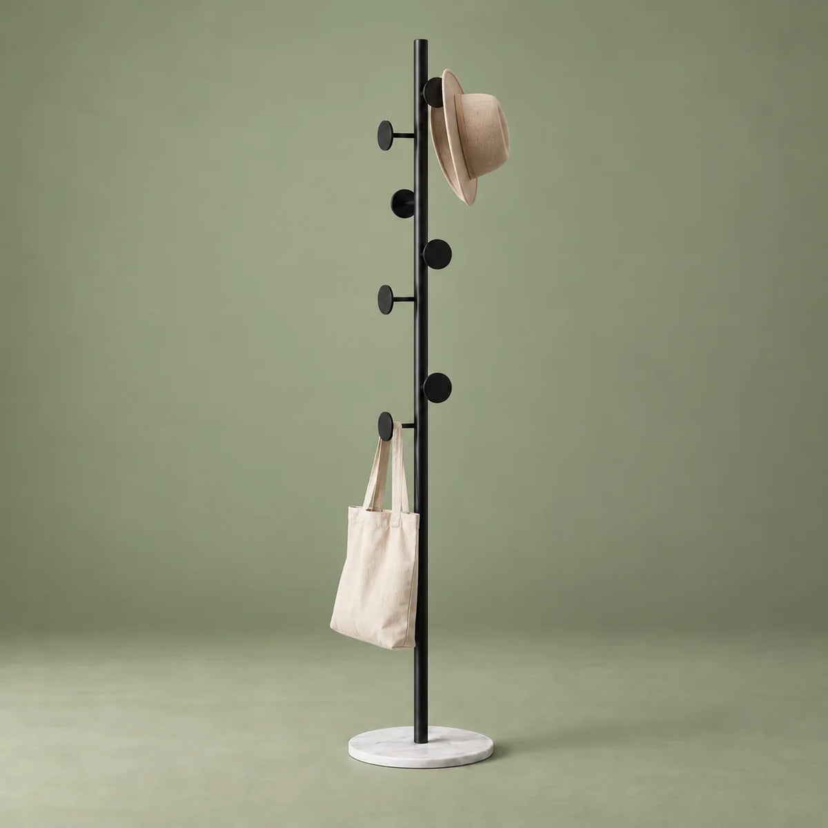 Porte-manteau champignon noir et blanc avec chapeau et sac en toile sur fond vert sauge