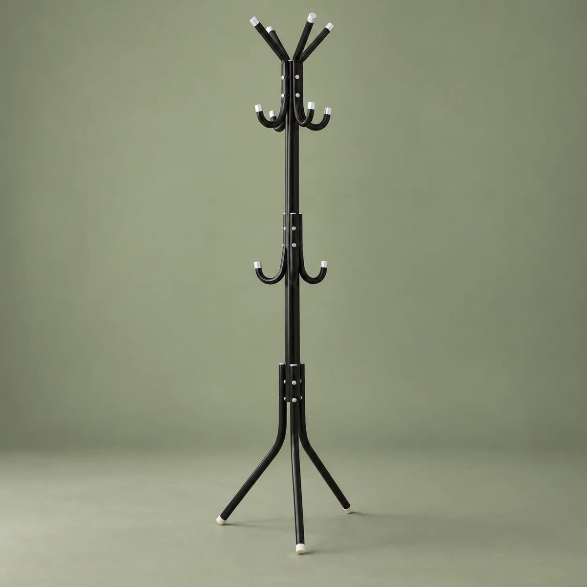 Porte-manteau perroquet noir vu en angle sur fond vert sauge