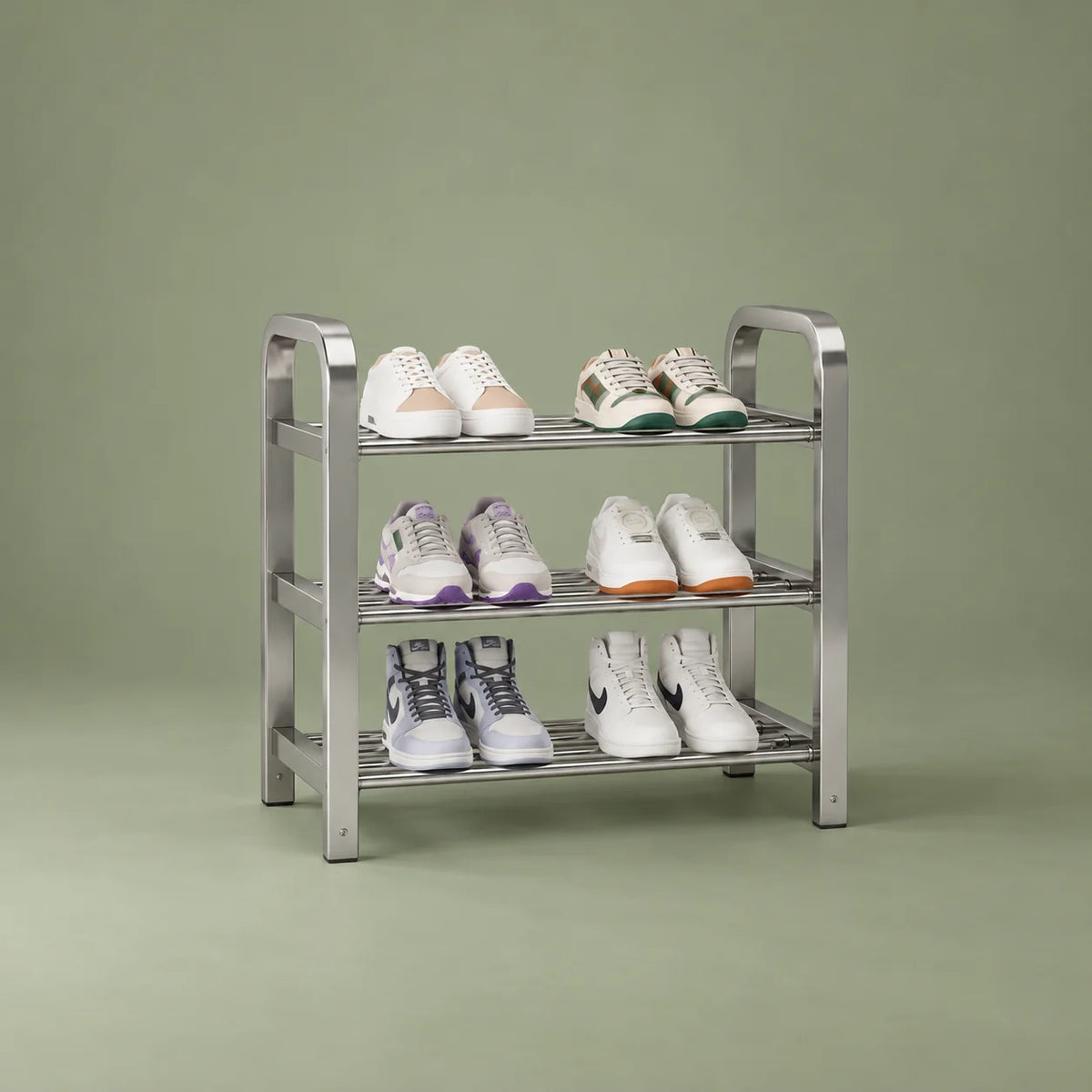Vue de trois quarts gauche du range-chaussures en acier argenté sur fond vert sauge