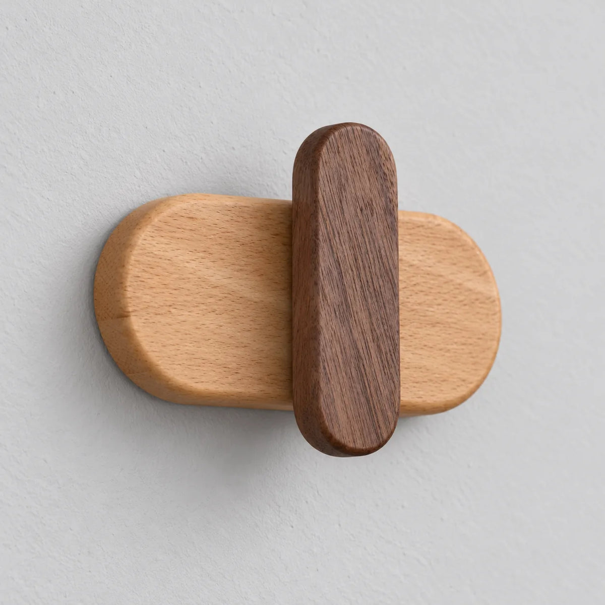 Vue rapprochée en angle de la patère capsule foncée montrant le relief du crochet sombre