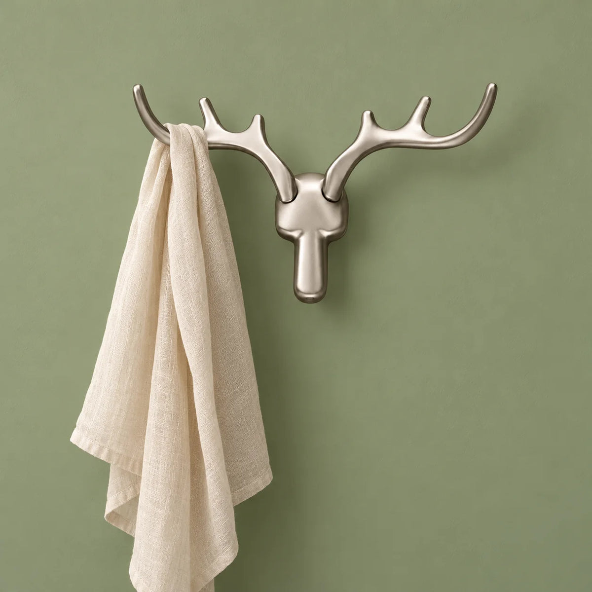 Patère cerf argentée portant un foulard sur fond vert sauge