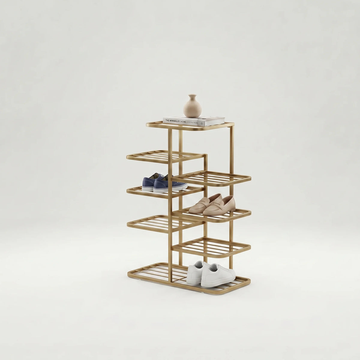 Vue studio d’origine du range-chaussures doré avec vase, chaussures bleu marine, mocassins beiges et chaussures blanches