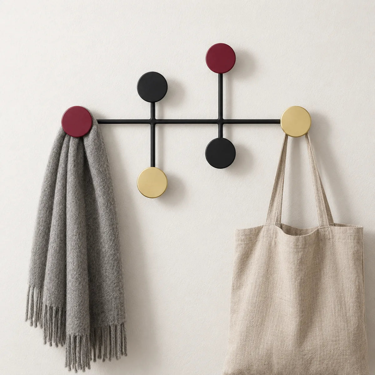 Porte manteau mural colore en usage avec une echarpe grise et un tote bag en lin