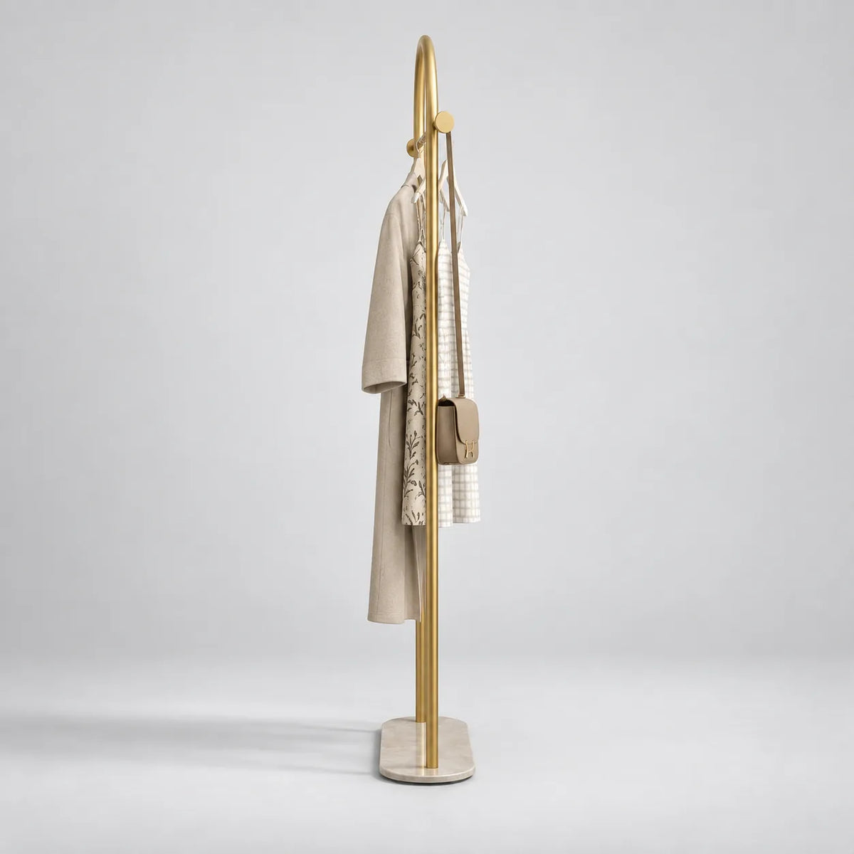 Porte Manteau sur Pied Courbé or vu de profil, structure fine en métal doré sur fond studio