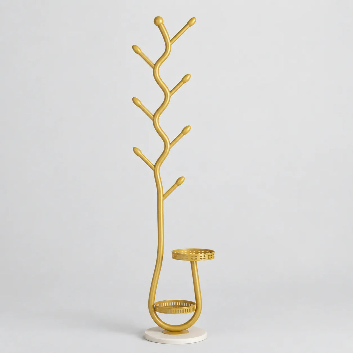 Porte manteau sur pied doré forme branche avec rangement bas, fond studio gris clair